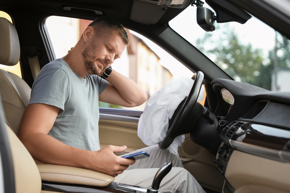 injured man rubbing his neck after being in a car accident